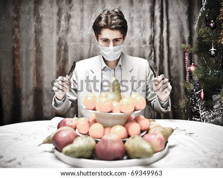 Ban for healthy food concept. Young man can`t eat fruits because of the breather on his mouth.