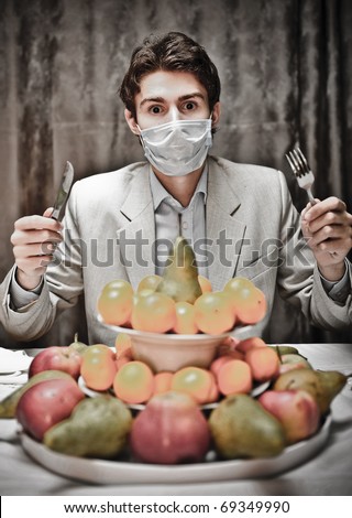 Ban for healthy food concept. Young man can`t eat fruits because of the breather on his mouth.