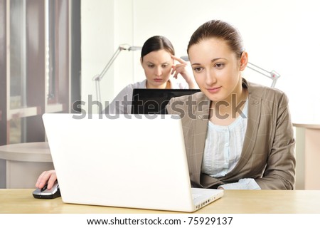 Portrait of relaxed and happy business woman in an office environment working with laptop