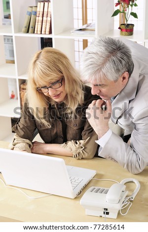 Portrait of two people working on the computer. Office background.