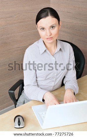 Portrait of a beautiful young businesswoman on the computer, looking up. Office location.