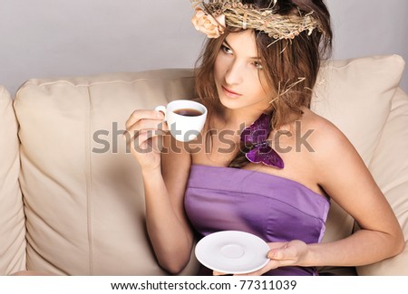 Closeup portrait of young beautiful lady drinking coffee sitting on comfortable couch at her apartment