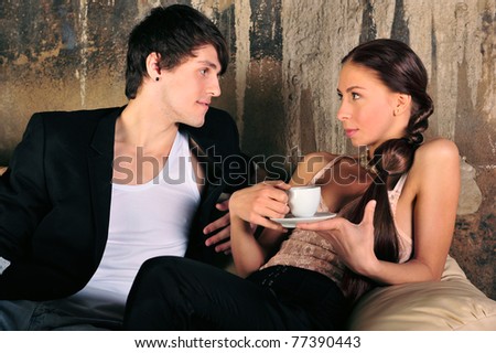 Fashion style photo of an attractive young couple at their grunge apartment at evening