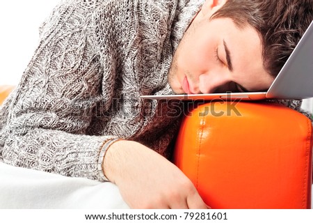 Portrait of young handsome student man laying on sofa using laptop for a long time. He is very tired