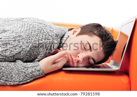 Portrait of young handsome student man laying on sofa using laptop for a long time. He is very tired