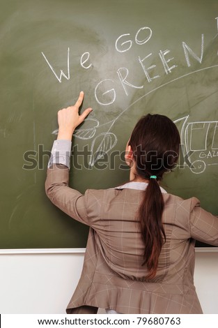 Closeup portrait of young pretty woman wearing formal suit erasing gasoline smoke on green board. Ecology care concept