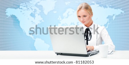Portrait of happy young business woman using her laptop. World map on the background