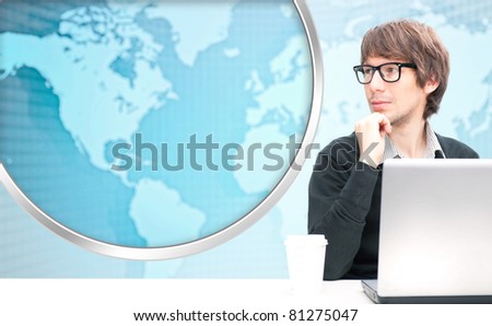 Portrait of happy young business man using his laptop. World map on the background