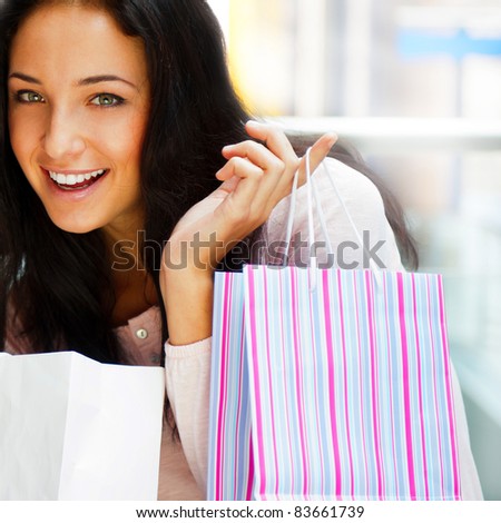 One excited shopping woman resting on bench at shopping mall looking at camera