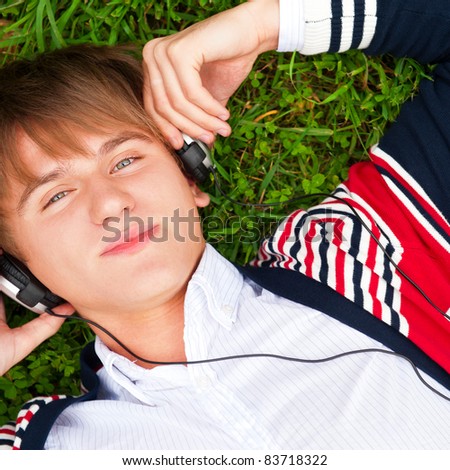 Student outside laying on grass and listening music school. Photo from above