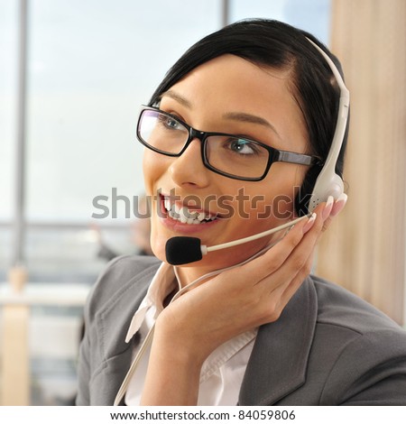 Portrait of a beautiful young businesswoman on the phone and happy. Office background.