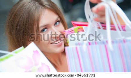 Happy woman at a shopping center holding bags with arms open. Seasonal preparty shopping boom