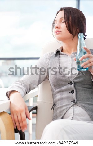 Beautiful business woman thinking about something while drinking cool fresh mineral water at her office