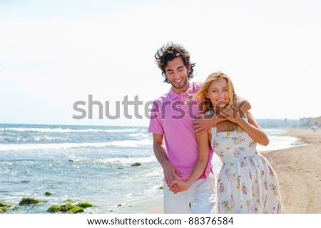 Couple at the beach holding hands and walking. Sunny day, bright colors. Europe, Spain, Costa Blanca