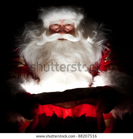 Santa sitting at the Christmas room and looking into the sack