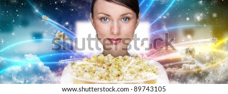 Portrait of young stylish modern woman  watching movie at modern cinema and eating exploding popcorn.