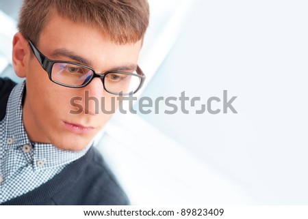 A university college student or casual good looking man wearing glasses portrait. Looking away