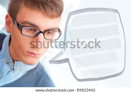 A university college student or casual good looking man wearing glasses portrait. Looking away. Blank balloon with his thoughts for your text and logo