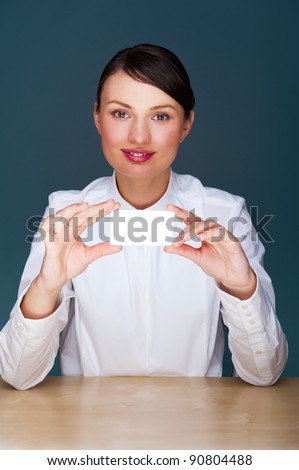 Young businesswoman showing her business card - sitting at her office