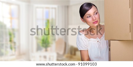Smiling woman at her home holding boxes. She is Moving at her new home. Mortgage concept