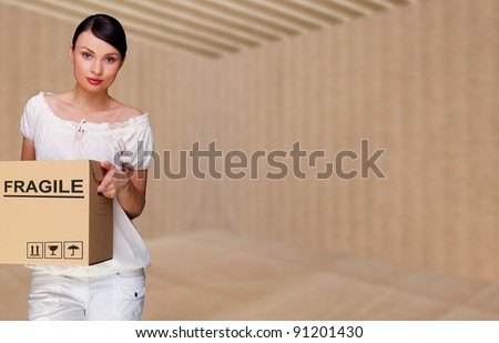 Closeup portrait of a young woman with boxes moving to her new home. Empty home packed into box. Everything is ready to move