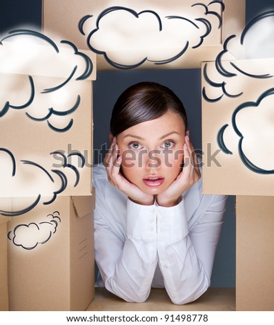 Portrait of young woman surrounded by lots of boxes. Lots of work concept. Help needed. Blank cloud balloons overhead