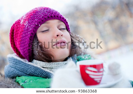 young beautiful girl day dreaming outdoors in winter while having coffee