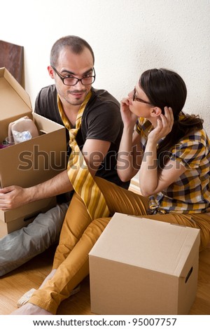 Young Couple with boxes in the new apartment sitting on floor and planning their future, dreaming about something positive