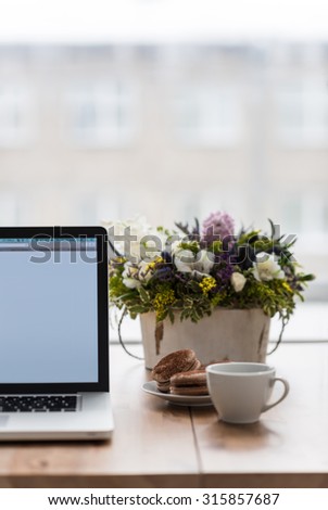 Female workplace with laptop, flowers and coffee