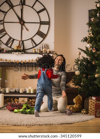 Mixed race mother and daughter hugging near Christmas tree