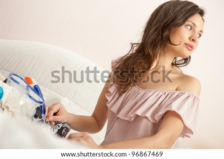 Portrait of young woman preparing for big trip and vacation she can not wait and have a big fun with packing her props and clothes