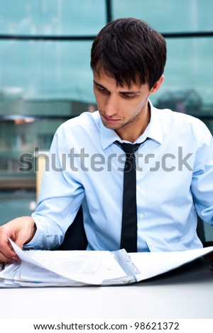 Portrait of a business man working at his office with papers