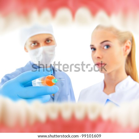 A dentist and a nurse curing patient. View from inside of mouth
