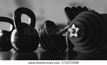 Dumbbells and kettlebells in black and white illustration.