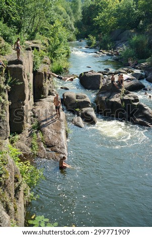 CORSUN-SHEVCHENKIVSKIY, UKRAINE - 24 JULY, 2015: young boys jump from a slope in the river of Ros\'. The river of Ros\' flows in the Tcherkasy area, Ukraine