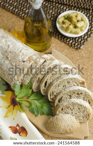 Sliced ciabatta bread on cutting board with olilve oil