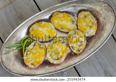 Potato skins. Baked potato halves stuffed with mushrooms, onion and cheese on rustic plate and wooden background. Copy space