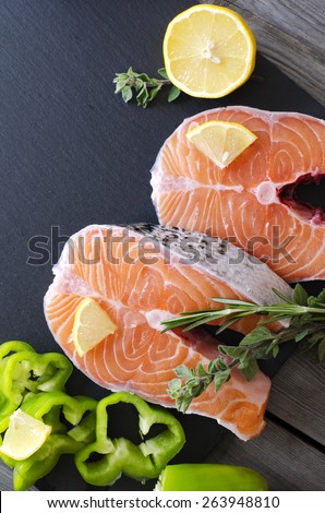 Fresh salmon fillet with aromatic herbs, spices, pink salt  and lemon. Healthy food, diet or cooking concept.