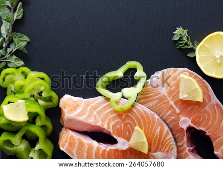 Fresh salmon fillet with aromatic herbs, spices, pink salt  and lemon. Healthy food, diet or cooking concept.