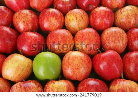 Green apple among red