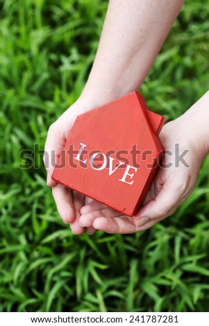 Red house in hands with \