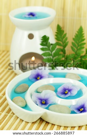 Flowers in a spiral bowl with oil burner