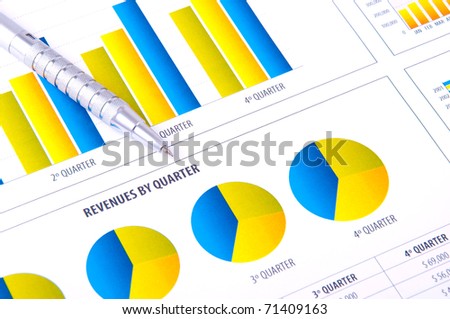 Analysis with charts of progress in business and metallic pen