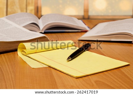 yellow legal pad on the table with books