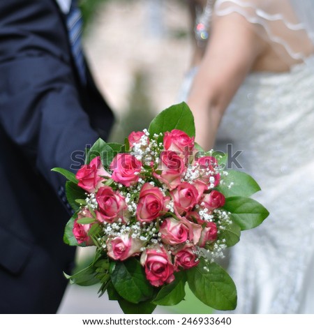 A wedding bridal bouquet composed of pink-white roses, white baby\'s breath and green leaves.