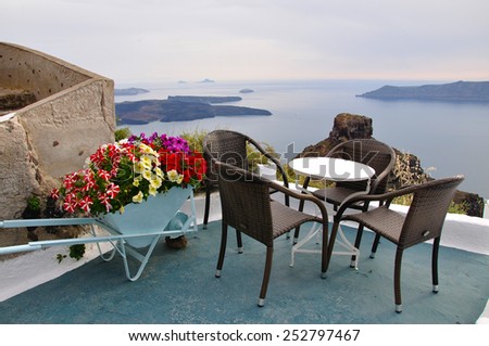Terrace in Greece with view of Aegean sea, decorated with flower cart