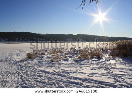 Sunny afternoon in winter at frozen lake