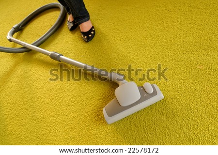 Cleaning of a green carpet with a vacuum cleaner