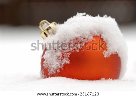 Red bauble covered with snow outside