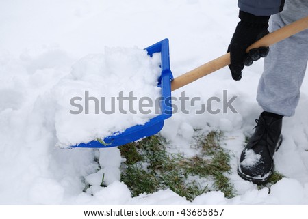 Man plowing snow in his garden with shovel